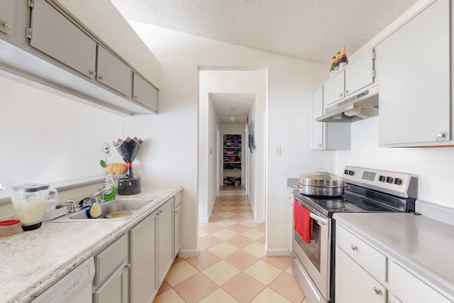 kitchen with stainless steel electric range, white dishwasher, sink, light tile patterned floors, and a textured ceiling