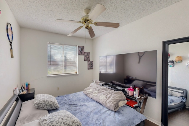 bedroom with hardwood / wood-style flooring, ceiling fan, and a textured ceiling