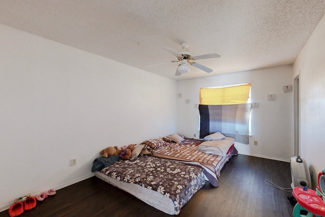 bedroom featuring a textured ceiling, dark hardwood / wood-style floors, and ceiling fan