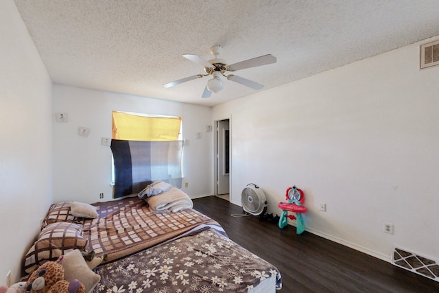 bedroom featuring ceiling fan, a textured ceiling, and dark wood-type flooring