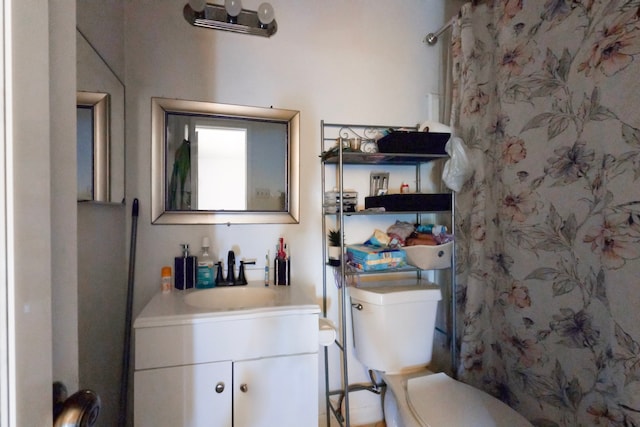 bathroom with a shower, vanity, and toilet