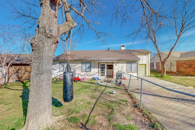 back of property with a garage and a yard