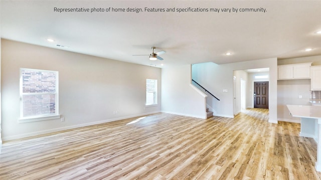 unfurnished living room featuring ceiling fan and light wood-type flooring