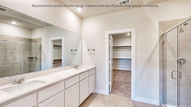 bathroom featuring tile patterned flooring, vanity, and a shower with shower door