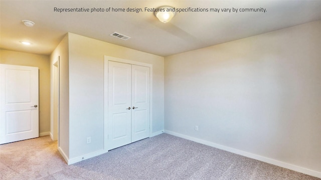 unfurnished bedroom featuring light colored carpet and a closet