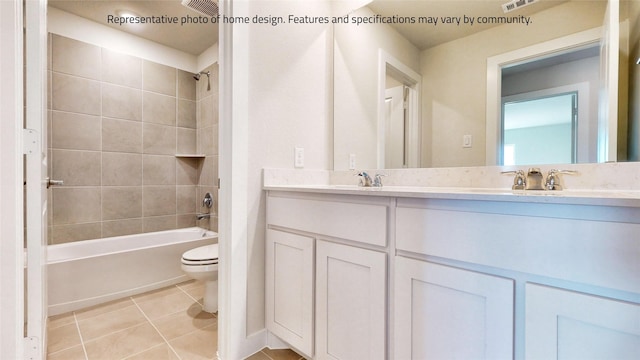 full bathroom with tile patterned flooring, tiled shower / bath combo, toilet, and vanity