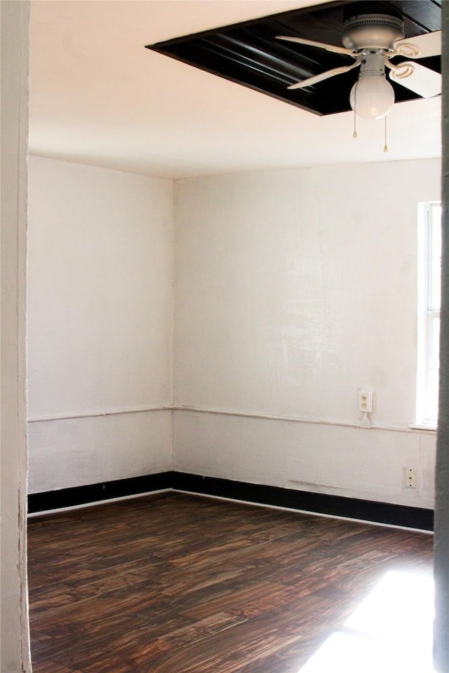 spare room with dark hardwood / wood-style flooring and ceiling fan