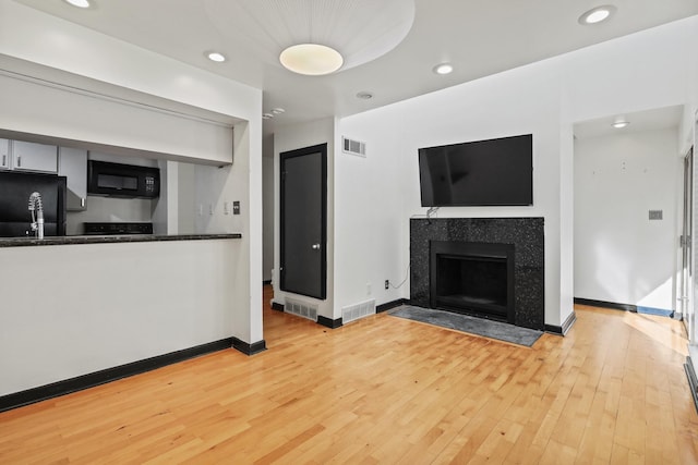 kitchen with black appliances and light wood-type flooring