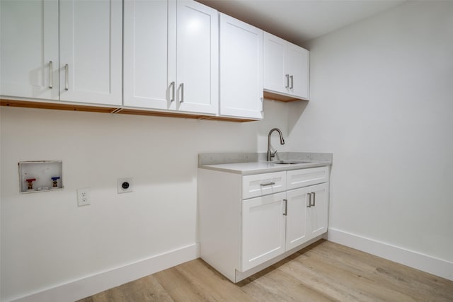 laundry room featuring cabinets, hookup for a washing machine, hookup for an electric dryer, sink, and light hardwood / wood-style floors