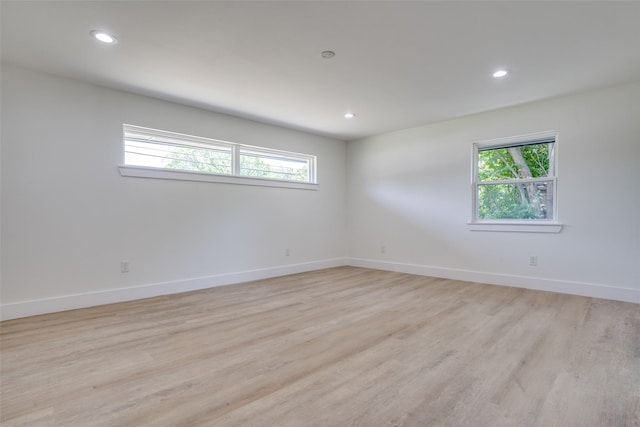 unfurnished room with light wood-type flooring and a wealth of natural light