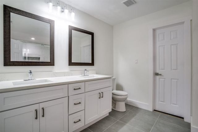 bathroom featuring tile patterned floors, vanity, toilet, and walk in shower