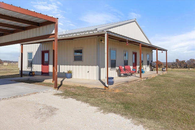 view of side of property featuring a patio area and a lawn