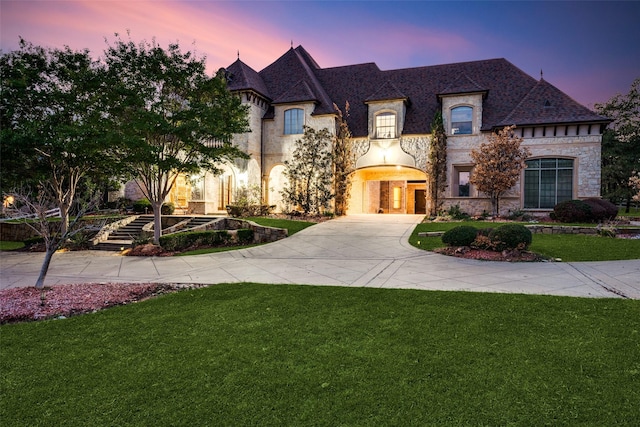 french country inspired facade with a yard