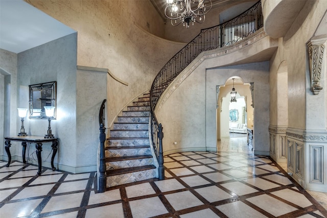 stairway featuring an inviting chandelier and a high ceiling