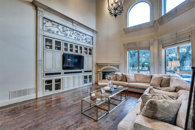 living room featuring a high ceiling, a chandelier, and dark hardwood / wood-style flooring