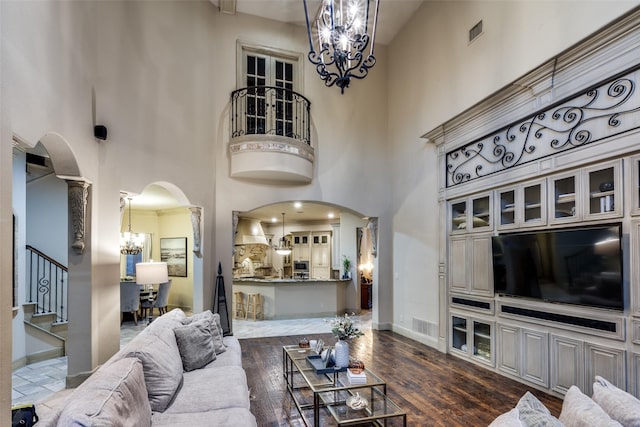 living room with a notable chandelier, dark hardwood / wood-style floors, and a high ceiling