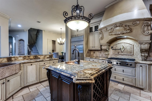 kitchen featuring sink, light stone counters, crown molding, a center island with sink, and appliances with stainless steel finishes