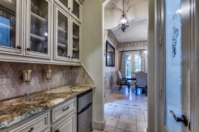 kitchen featuring stainless steel refrigerator, decorative light fixtures, decorative backsplash, light stone countertops, and french doors