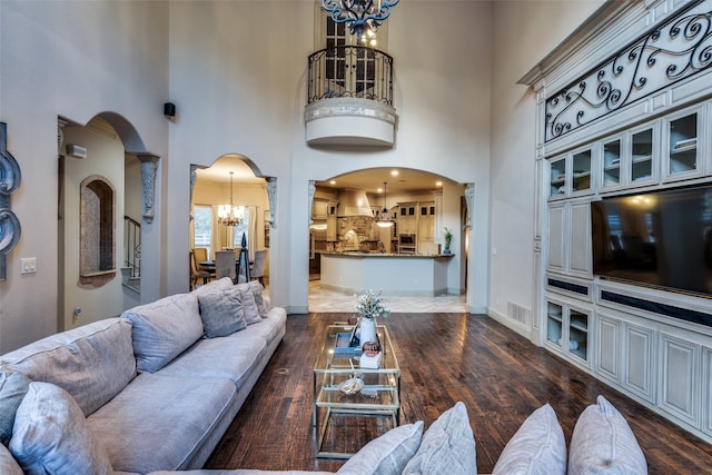 living room featuring dark hardwood / wood-style flooring, a high ceiling, and a notable chandelier