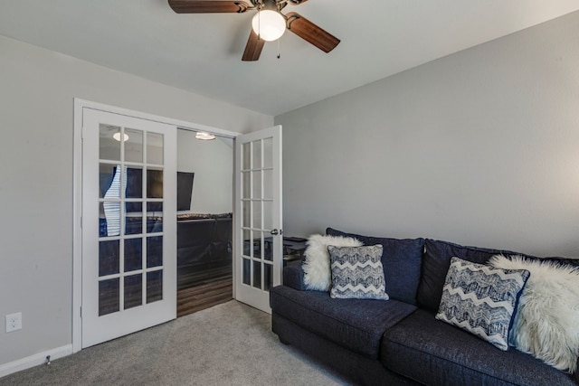 carpeted living room with ceiling fan and french doors