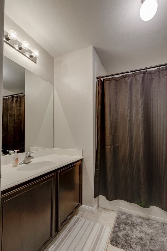 bathroom featuring tile patterned flooring, vanity, and a shower with shower curtain