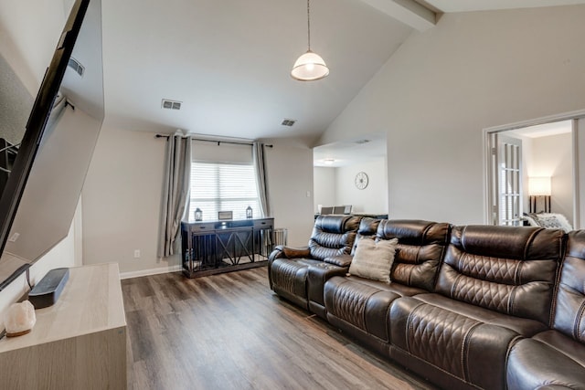 living room with hardwood / wood-style flooring, high vaulted ceiling, and beam ceiling