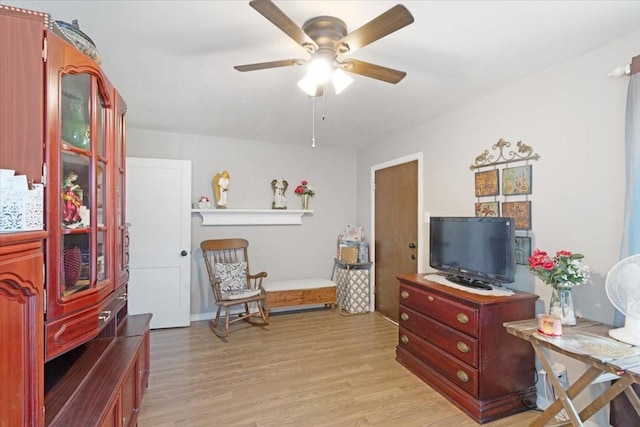 living area with light hardwood / wood-style floors and ceiling fan