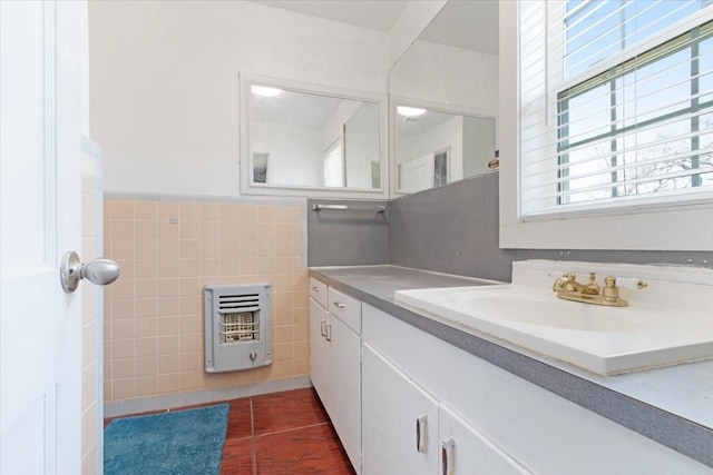 bathroom featuring vanity, heating unit, tile patterned floors, and tile walls