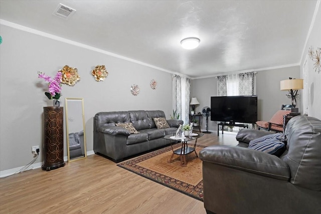 living room with light hardwood / wood-style flooring and crown molding