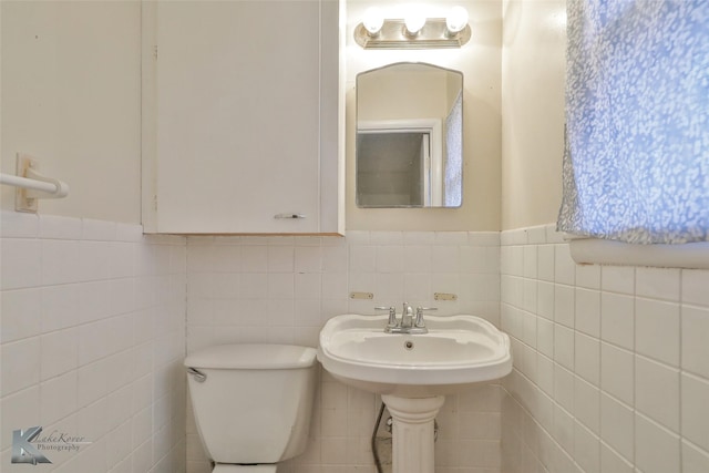 bathroom featuring tile walls and toilet