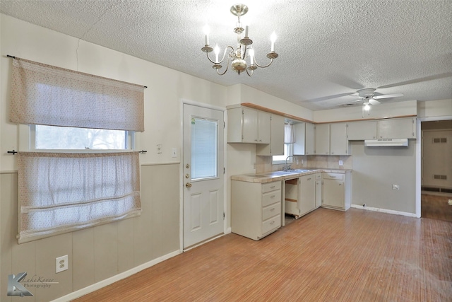 kitchen featuring white cabinetry, sink, light hardwood / wood-style floors, a textured ceiling, and ceiling fan with notable chandelier