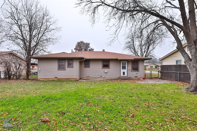 rear view of property featuring a lawn