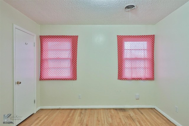 empty room featuring hardwood / wood-style floors and a textured ceiling