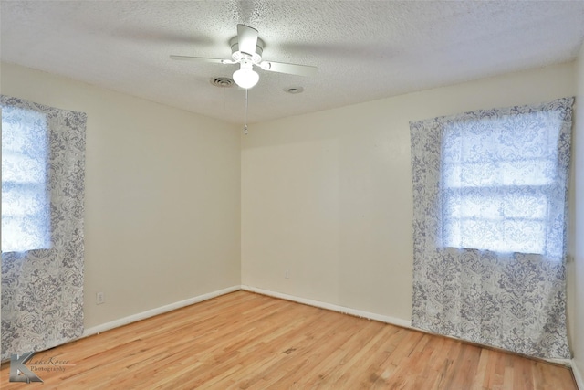 empty room featuring ceiling fan, wood-type flooring, and a textured ceiling