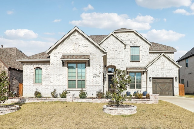 french country home with a garage and a front lawn