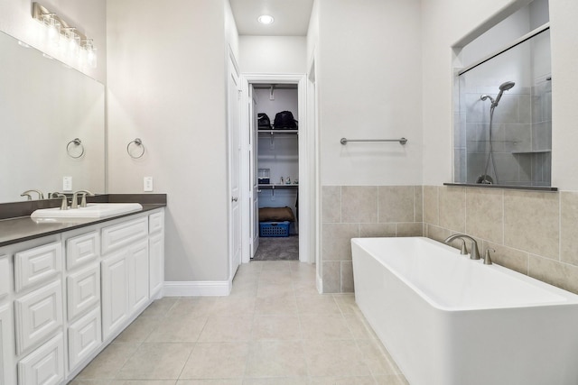 bathroom with tile patterned flooring, vanity, and shower with separate bathtub