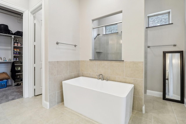 bathroom with tile patterned flooring, independent shower and bath, and tile walls