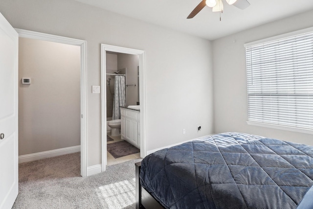 bedroom with ceiling fan, ensuite bathroom, and carpet floors