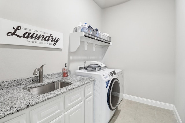 washroom with cabinets, independent washer and dryer, and sink