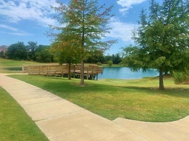 surrounding community featuring a water view and a yard