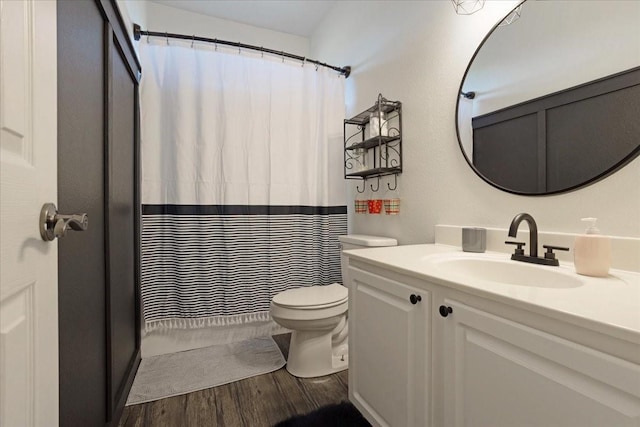 bathroom with wood-type flooring, toilet, a shower with shower curtain, and vanity