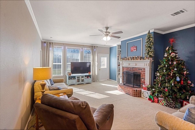 living room with ceiling fan, ornamental molding, a fireplace, and carpet