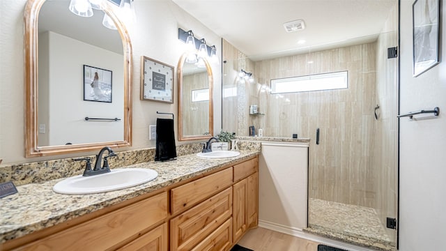 bathroom featuring wood-type flooring, vanity, and a shower with door