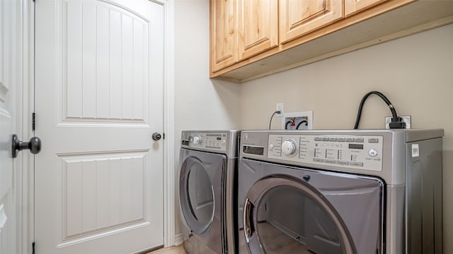 laundry room with washer and dryer and cabinets