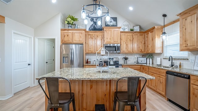 kitchen with pendant lighting, appliances with stainless steel finishes, and a kitchen island