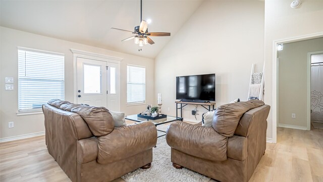 living room with ceiling fan, high vaulted ceiling, a healthy amount of sunlight, and light wood-type flooring