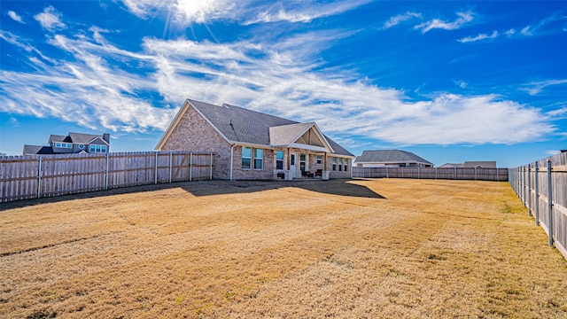 rear view of property featuring a lawn