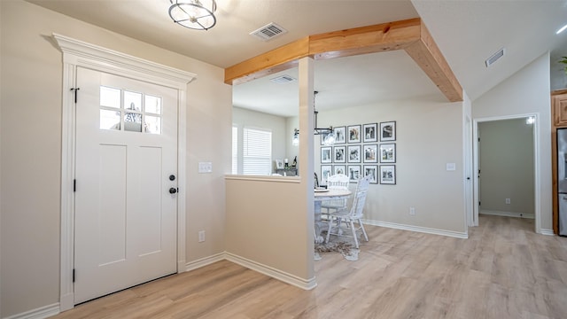 foyer featuring vaulted ceiling with beams and light hardwood / wood-style flooring