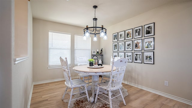 dining area with an inviting chandelier, light hardwood / wood-style flooring, and a wealth of natural light