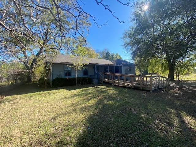 rear view of house with a wooden deck and a yard